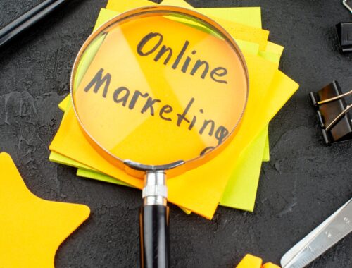 bottom view online marketing written on sticky notes scroll and star sticky notes scissors binder